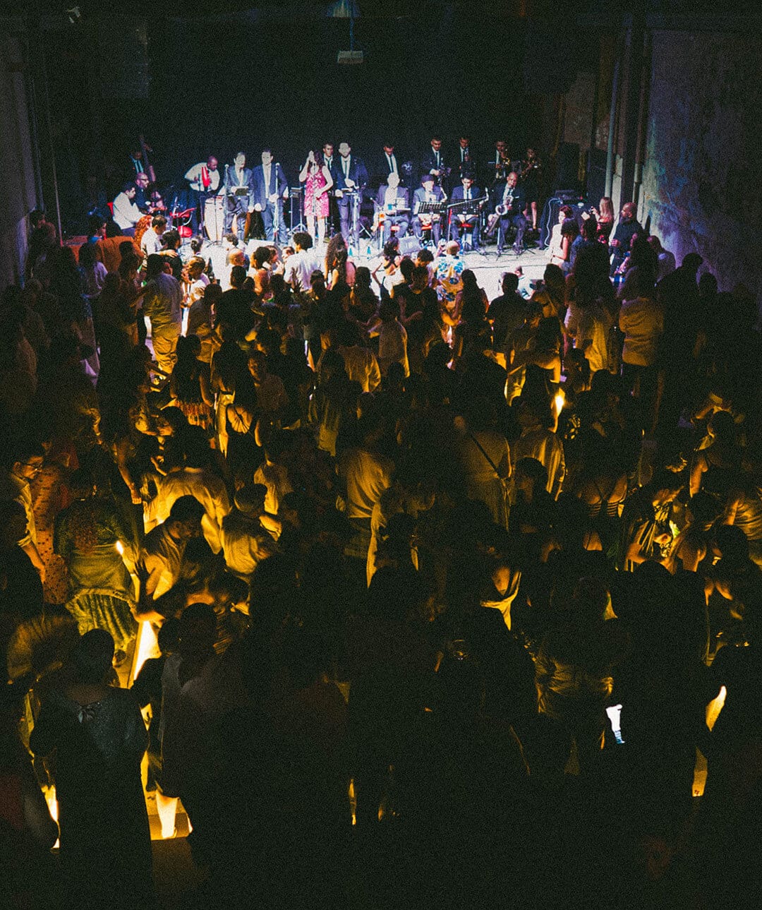Grupo de personas en un teatro viendo la presentación de un grupo musical, trabajamos para generar un impacto económico positivo, fomentando el desarrollo sostenible y el crecimiento inclusivo.