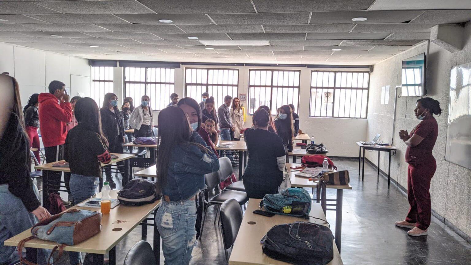 Young people in their classroom, standing up from their desks and looking at the guidelines given by their teacher. With a clear vision of sustainable development, we implement transformative initiatives that produce significant environmental and economic impact.