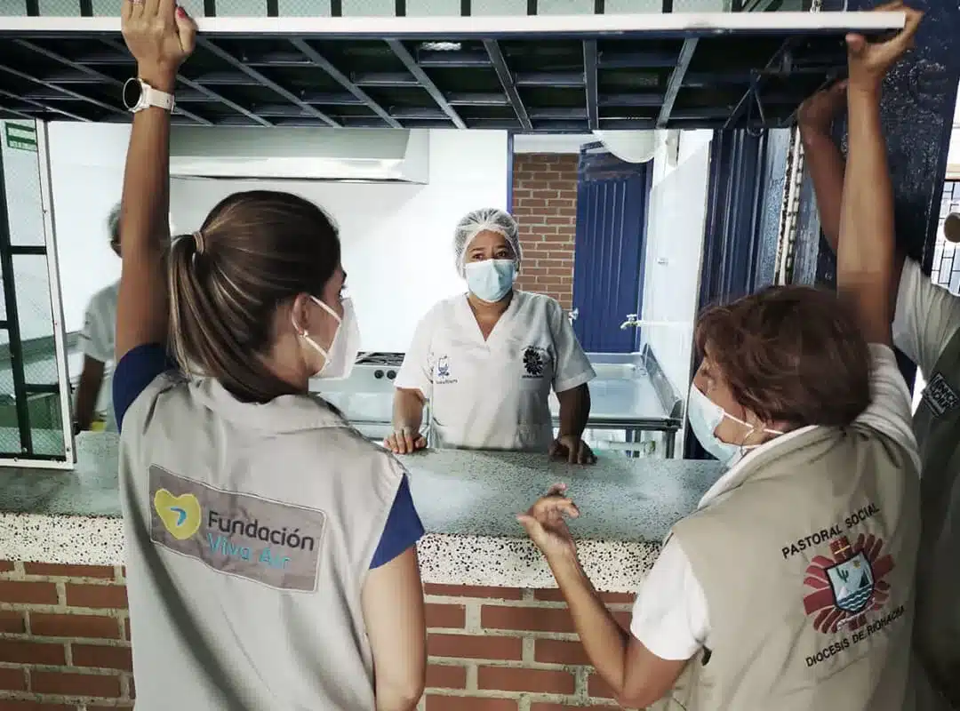 Two women consulting and verifying the entrepreneurship of a woman who has benefited from One inversión's impact strategies.