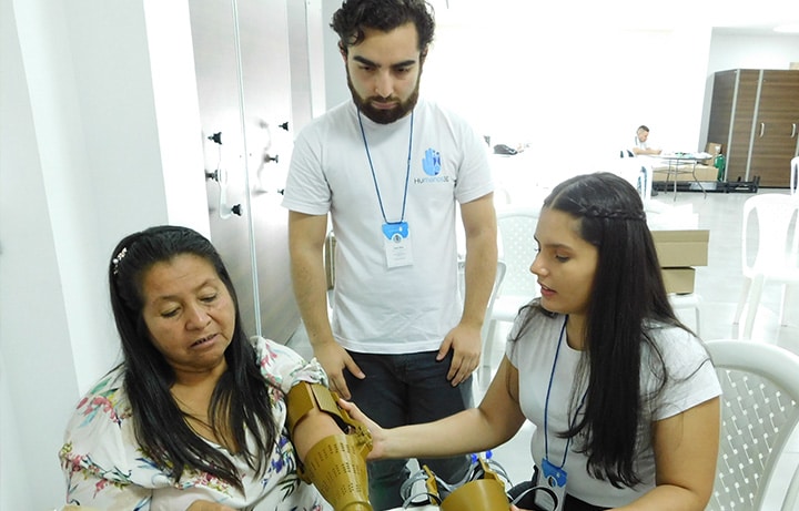 Tres personas, una de ellas mostrando su brazo asegurando su beneficio frente a la innovación social de one inversión