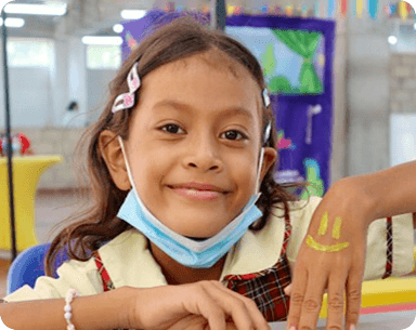 Niña sonriendo ,A través de proyectos sociales y iniciativas transformadoras, buscamos alcanzar un triple impacto y promover el desarrollo sostenible