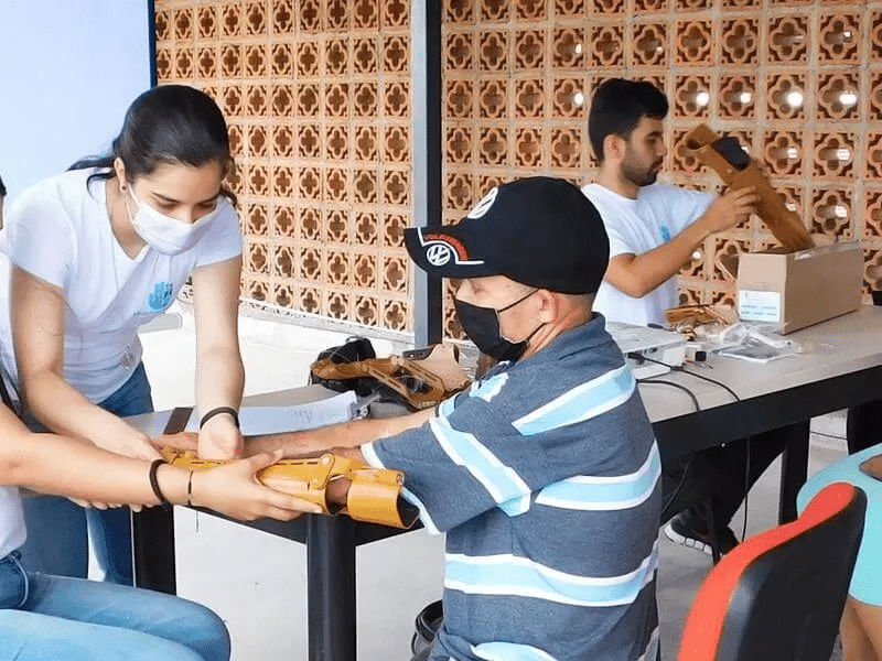 A man receiving a prosthetic hand. Strategic philanthropy and patient capital are essential for our high-impact and triple-impact actions