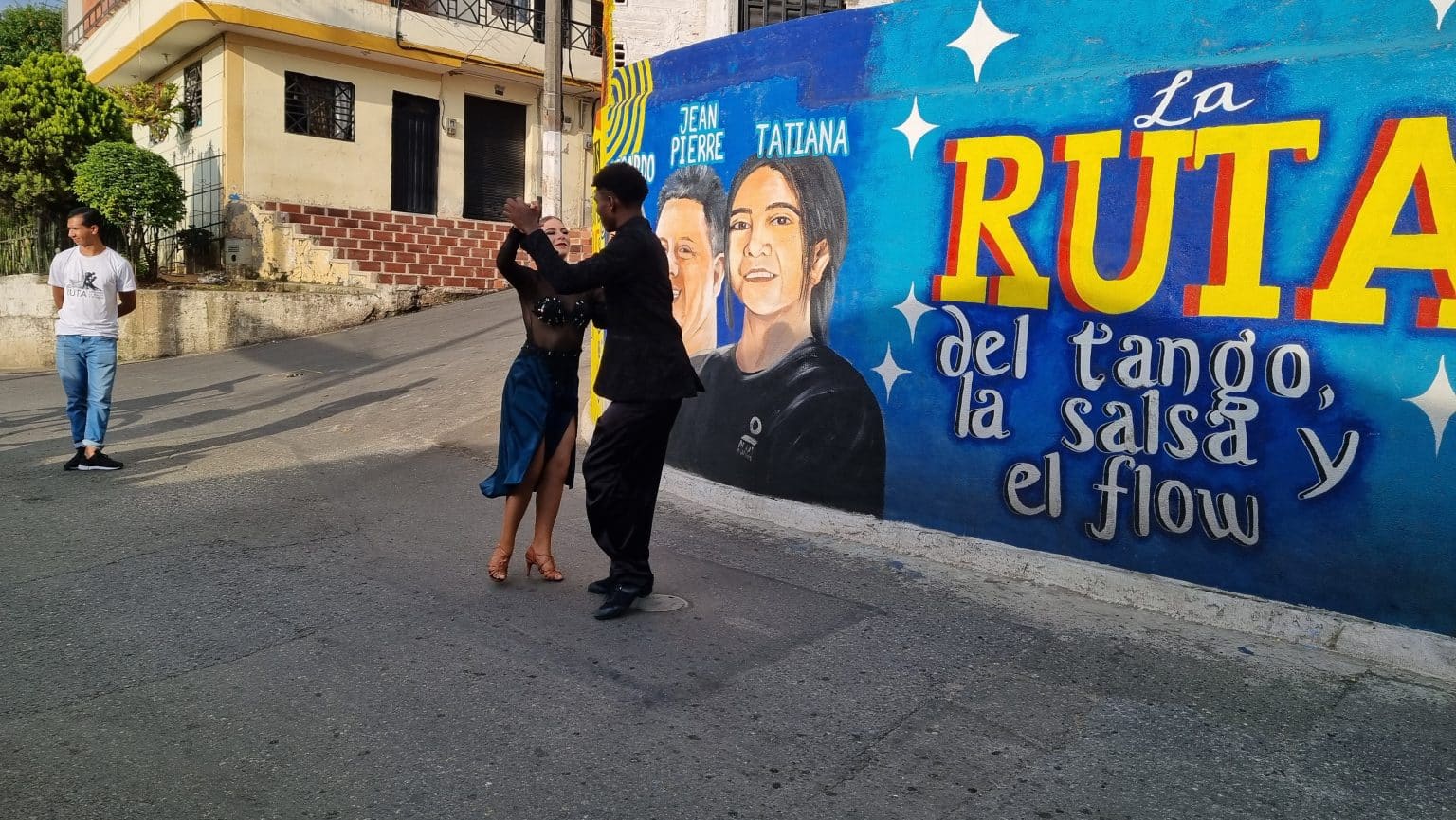 A young salsa dancing couple on the corner of a community. Through social projects and transformative initiatives, we aim to achieve triple impact and promote sustainable development.