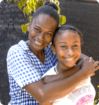 Mujeres abrazando a una joven y las dos sonriendo , Encontramos las mejores ideas, iniciativas o proyectos, los fortalecemos para generar cambios positivos y los impulsamos para que juntos multipliquemos el impacto.