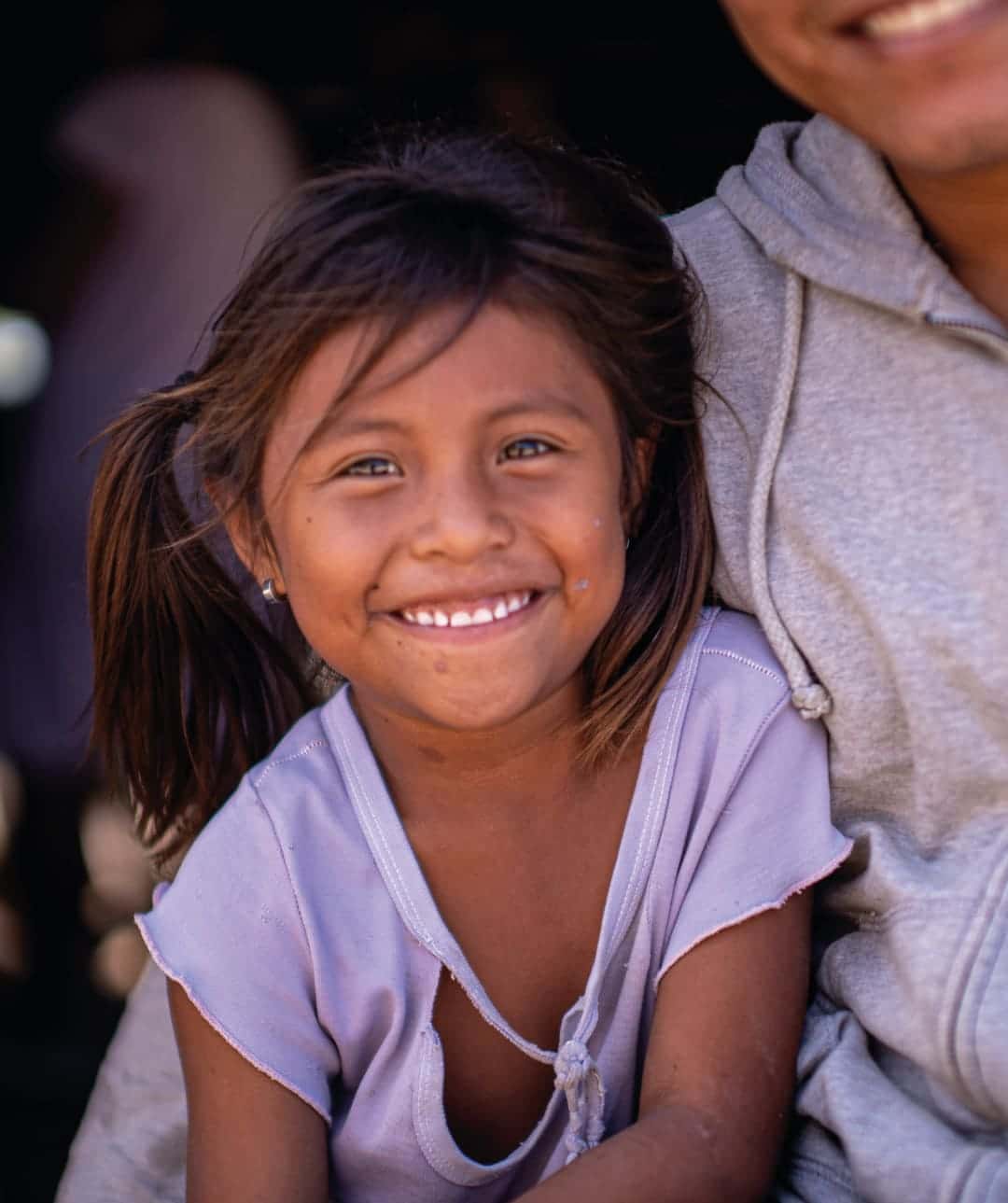 Niña de escasos recursos sonriendo, dando importancia a Las iniciativas transformadoras impulsan el desarrollo sostenible y fomentan un cambio significativo en la sociedad.